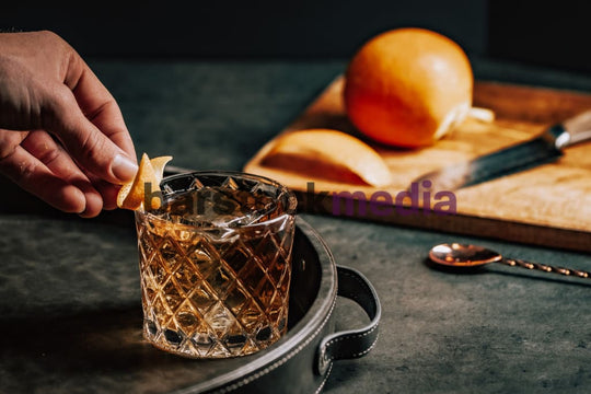 Old Fashioned on Dark Leather Tray With Hand Garnishing