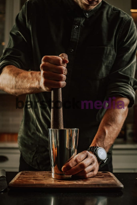 Home Bartender Muddling a Cocktail in Tin